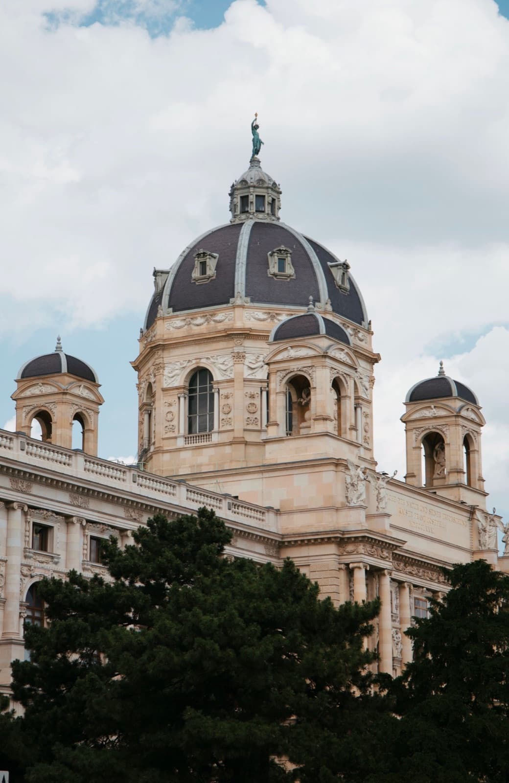 Naturhistorisches Museum Wien: the dome and towers behind the pines of the square