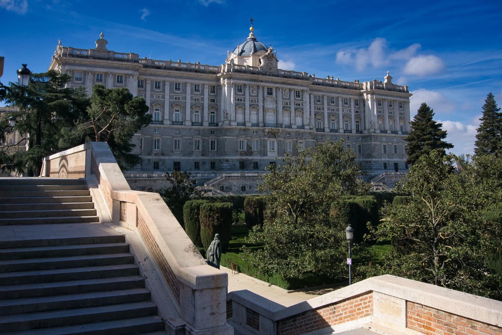 Royal Palace of Madrid: the palace above the stairs and trees of the gardens