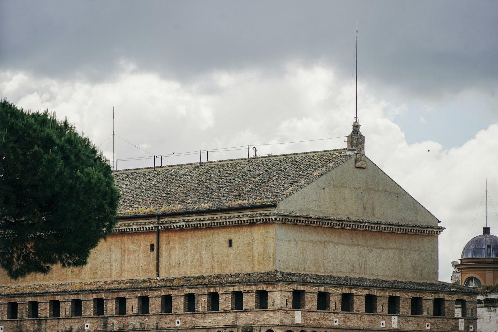 Vatican Museums: the plain brick block of the Sistine Chapel under a storm sky